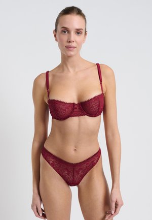 Burgunderfarbene Spitzen-BH und passender Tanga mit detaillierten Mustern, verstellbaren Trägern und gezackten Kanten. Weiche Textur mit floralen Designelementen.
