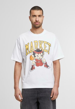Hvid bomulds T-shirt med løs pasform, der har et farverigt grafik af en figur, der holder en basketball og ordet "MARKED" i gult.