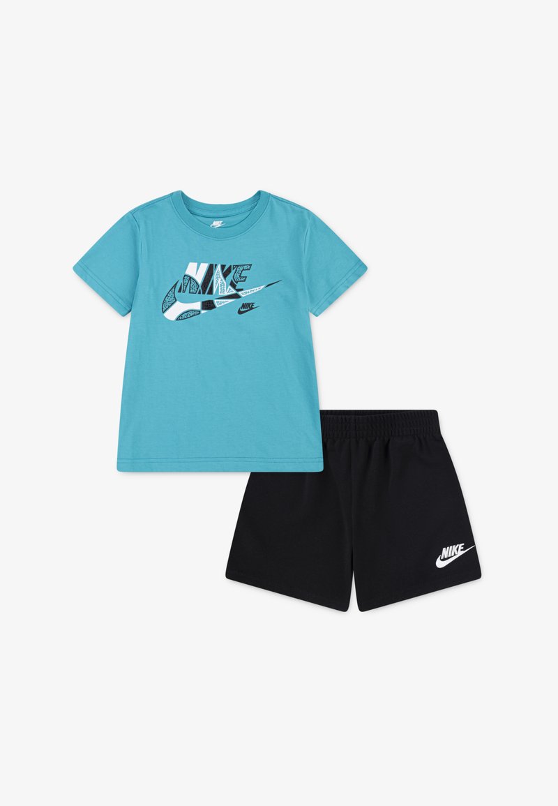 Kék pamut póló fekete és fehér Nike logónyomattal, fekete sorttal párosítva, amelynek a szegélyén fehér Nike logó található.