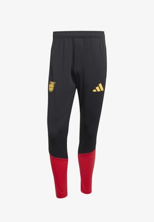 Černé sportovní kalhoty s červenými spodními nohavicemi, elastickým pasem a žlutými logy na horních stehnech, včetně sportovního erbu a značkového symbolu.