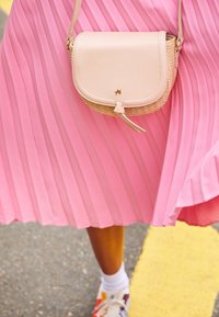 Borsa a tracolla realizzata in morbida pelle rosa pallido con dettagli in paglia intrecciata, con logo dorato e chiusura delicata.
