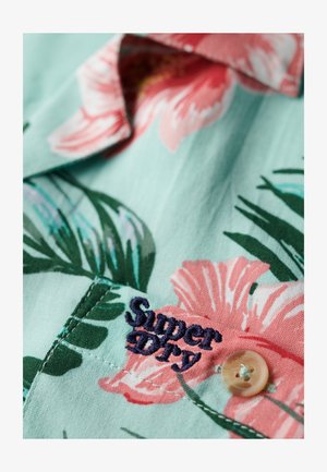 Koszula z krótkim rękawem w miętowym kolorze z różowym kwiatowym wzorem. Posiada haftowaną metkę "Super Dry" oraz jasny guzik jako detal.