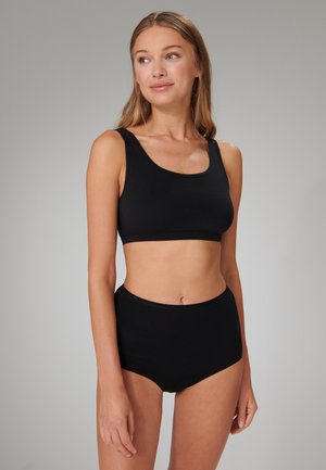 Completo in cotone nero a due pezzi, composto da un top corto con scollatura a barca e slip a vita alta. Design semplice senza motivi visibili o accessori.