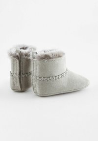 Bottines en daim gris avec doublure en fausse fourrure, comportant des coutures décoratives et des linguets pour un enfilage facile. Bout arrondi et texture douce.