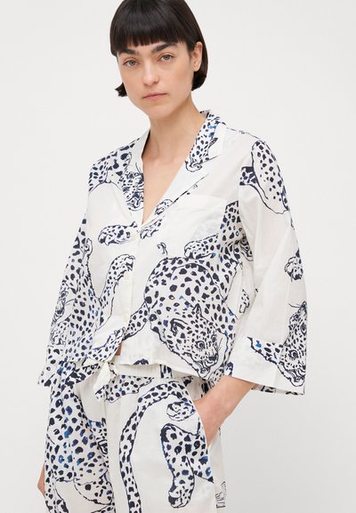 Biały zestaw odzieży loungewear z nadrukiem w panterkę w odcieniach niebieskiego i czarnego. Koszula posiada kołnierzyk, guziki i kieszeń; spodnie mają elastyczny pas.
