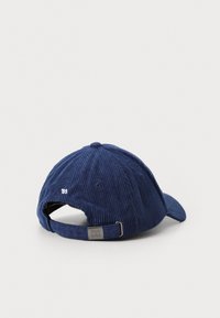 Navy corduroy baseball cap with adjustable strap, features a small white '85' stitching on the back, textured fabric, and curved brim.