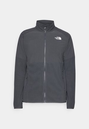Dark gray fleece jacket with a high collar, full front zipper, textured upper yoke, side pockets, and a white logo on the chest.