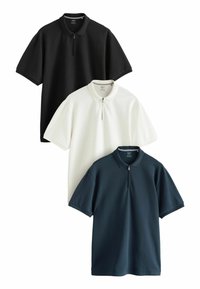 Drie korte mouwen polo-shirts in zwart, wit en marineblauw, met een half-rits kraag en gestructureerde stof.