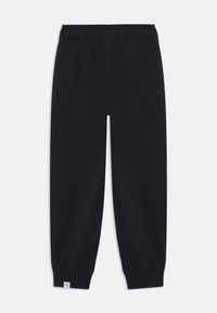Black jogger pants made of soft fabric, featuring a stretch waistband and elastic cuffs. Includes a small logo tag at the hem.