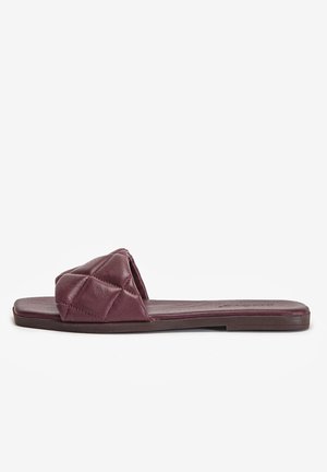 Flad slip-on sandal med quiltet polstret rem i mørk bordeaux læder og en flad sål mod en hvid baggrund.