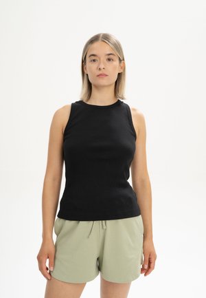 Zwarte geribbelde tanktop met een ronde hals, mouwloos ontwerp en een getailleerde pasvorm, gecombineerd met lichtgroene drawstring shorts.