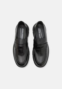 Schwarze Lederloafer mit glatter Oberfläche, ausgestattet mit einem dekorativen Riemen und dezenten Stickdetails. Markenlogo auf der Innensohle sichtbar.