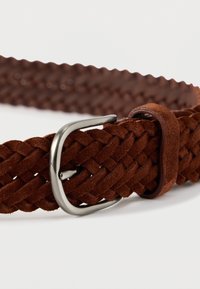 Cinturón trenzado de ante marrón con hebilla rectangular de plata y presilla de ante a juego sobre fondo blanco.