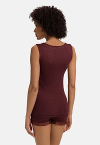 Bordeaux värillä varustettu hihaton toppi, jossa on ribbikuvio, yhdistettynä vastaaviin shortseihin, joissa on pitsireunus. Istuvuus on vartalonmyötäinen.