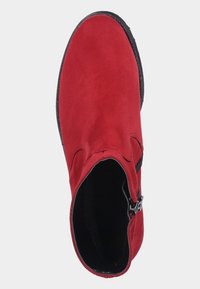 Röd mocka ankelsko med sidizipp, rund tå och en texturerad svart sula. Slät inre yta och låg klack.