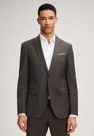 Ciemnoszary garnitur z teksturowanej tkaniny. Posiada klapę w kształcie litery notched, dwie przednie kieszenie, zapięcie na jeden guzik oraz białą koszulę pod spodem.