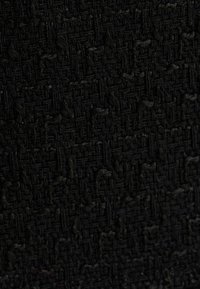 Tejido negro texturizado con un patrón tejido y acentos en relieve, creando un rico detalle superficial, adecuado para diversas aplicaciones textiles.