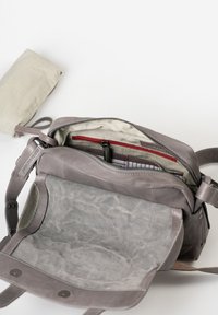 Borsa in pelle grigia con una texture morbida, dotata di chiusura con zip, fodera interna a righe e una tasca più piccola. Include chiusura a due bottoni magnetici.