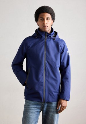 Navy blue waterproof jacket with a hood, featuring a front zipper and two side pockets. Made of smooth, lightweight fabric with minimal accents.
