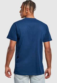 Marinblå T-shirt med korte ærmer lavet af bomuld; standard pasform med rund hals og glat overflade. Enkel design uden synlige grafikker.