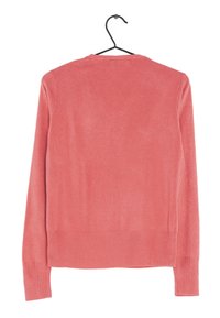 Pull en corail à manches longues avec un col rond, des poignets et un ourlet à côtes, fabriqué en tissu tricoté lisse, accroché à un crochet noir.