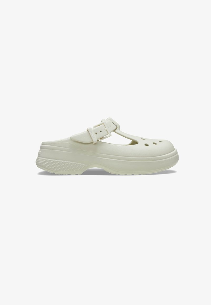 White clog-style shoe featuring a T-strap design, adjustable buckle, and ventilation holes. Made from durable material with a textured sole.