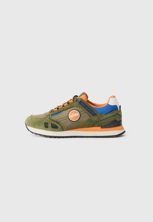 Green suede and fabric sneaker with orange, blue, and black accents, featuring a round logo, lace-up front, and textured sole.