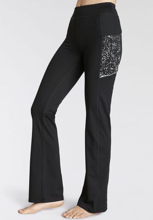 Black athletic pants with a fitted design, featuring a speckled black and white pocket, flat seams, and a flared leg.