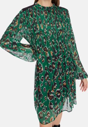 Grünes transparentes Kleid mit schwarzem, braunem und weißem Leopardenmuster, gerafftem Oberteil, langen Puffärmeln und schwarzen Schulterakzenten.