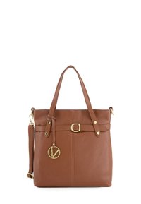 Sac à main en cuir brun avec une finition texturée, présentant un charme circulaire en métal doré, des bretelles ajustables et une silhouette structurée.