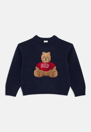 Suéter de punto azul marino con un gráfico de un oso de peluche que lleva una camiseta roja con el texto "GAP", cuello redondo y puños y dobladillo acanalados.