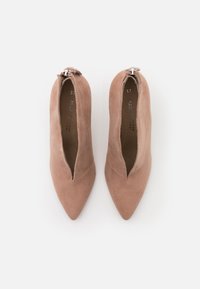 Botines de ante rosa con punta afilada y un corte en forma de V, con un detalle de cremallera plata en la parte posterior, talla 37. Textura suave.