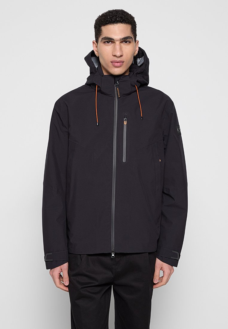 Giacca impermeabile nera con zip frontale, cappuccio regolabile, cordini arancioni e dettagli grigi. Presenta una tasca sul petto e polsini elasticizzati.