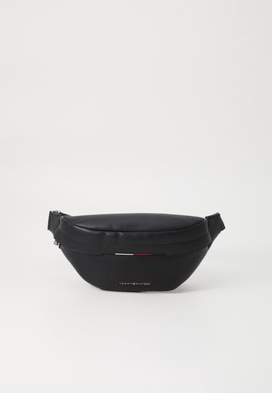 Schwarze Leder-Tasche von Tommy Hilfiger mit verstellbarem Tragegurt und kleinem Detail mit roter, weißer und blauer Flagge vorne.