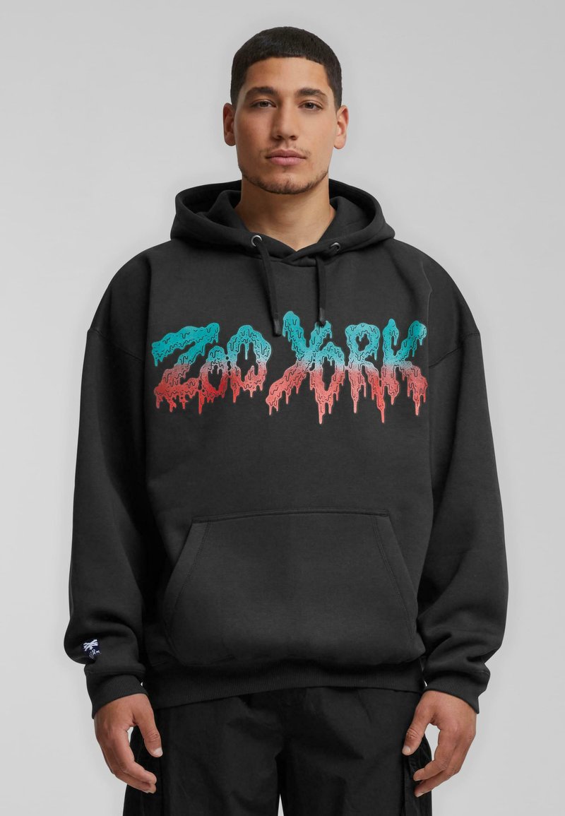 Black hoodie with a front kangaroo pocket, featuring colorful, drippy text "Zoo York" in turquoise and red. Cotton material, relaxed fit.