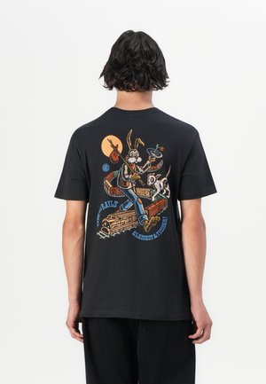 Black cotton t-shirt featuring a colorful graphic print on the back of a rabbit and a dog, with a sunrise and train elements.