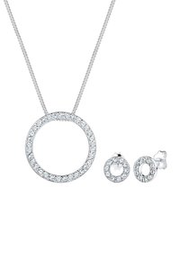 Silberne Halskette mit einem runden Anhänger, der mit klaren Kristallen besetzt ist, kombiniert mit passenden runden Ohrringen.