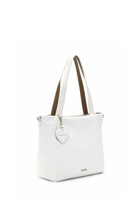 Bolso tote de cuero blanco con forma estructurada, asas dobles y una etiqueta en forma de corazón adjunta. El interior cuenta con un forro de tela marrón.