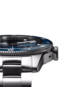 Silberner Edelstahl-Armbanduhr mit blauem Lünette und schwarzem Zifferblatt. Verfügt über eine strukturierte Kante an der Lünette, leuchtende Zeiger und ein Armband.