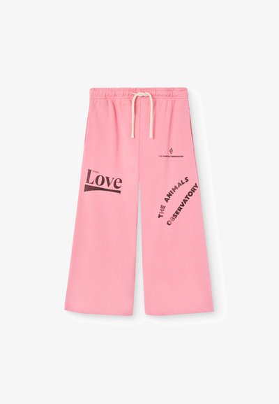 Ružové bavlnené teplákové nohavice so širokým strihom. Obsahujú potlač s textom "Láska" a "THE ANIMALS OBSERVATORY" v čiernej farbe. Sťahovanie v páse.