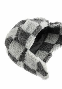 Bonnet en polaire à carreaux gris et blancs avec une texture douce, présentant un motif épais et un revêtement en tissu foncé à l'intérieur.