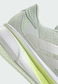 Lichtgrijze sportschoen met een gemêleerd mesh bovenwerk en witte accenten. Voorzien van een lichtgroene streep en het merkdetail "DURAMO SL2".