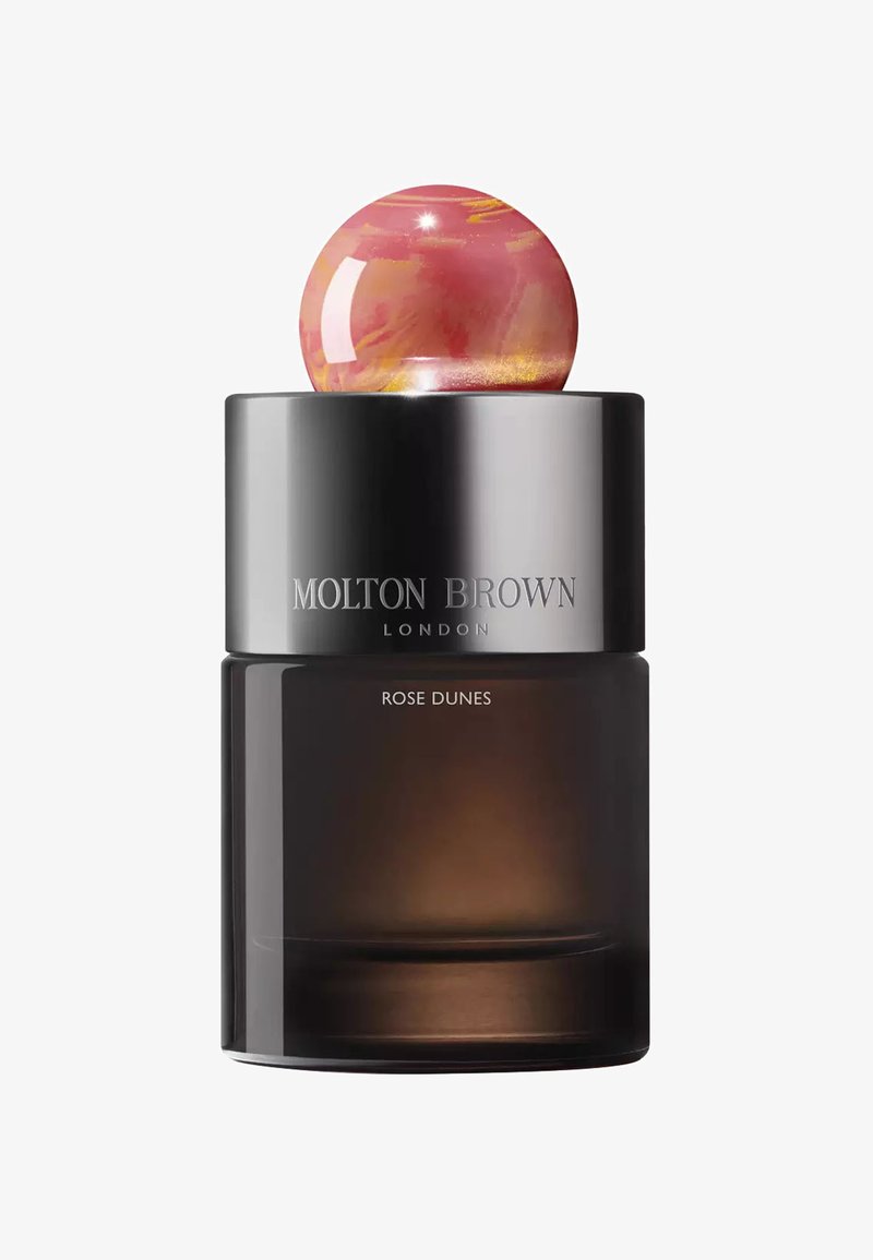 Die Flasche des Molton Brown Rose Dunes Duftes verfügt über einen dunklen Glas-Korpus, einen metallischen schwarzen Deckel und einen sphärischen rosa Akzent obenauf.