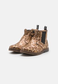 Bottes chevilles imprimé léopard avec finition dorée métallique, panneaux latéraux élastiques, languettes noires et semelles en caoutchouc marron. Talon plat et court.