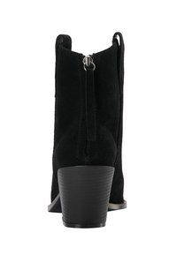 Stivali alla caviglia in suede nero con tacco affusolato, dettaglio con zip sul retro e suola sintetica testurizzata. Finitura opaca, design minimalista.