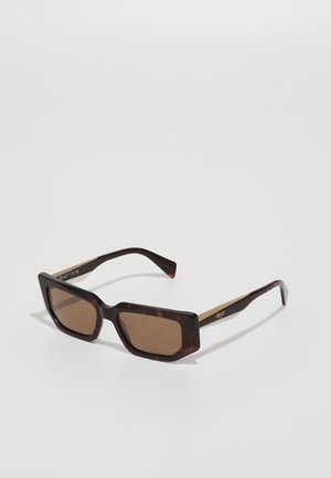Occhiali da sole con tonalità marrone, montatura in tartaruga scura, forma rettangolare, bordi spessi e dettagli dorati sulle tempie.