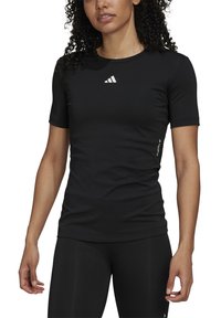 Black athletic shirt made of stretchy fabric; short sleeves, crew neckline; features a small white logo on the chest and side.