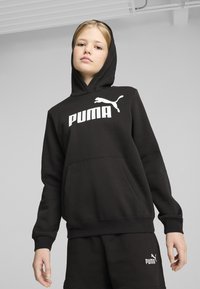 Felpa nera con cappuccio e logo "PUMA" bianco, dotata di tasca frontale a marsupio e polsini a costine. Il materiale appare morbido e resistente.