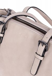 Beige leren handtas met zwarte accenten, voorzien van meerdere compartimenten, stevige hengsels en een subtiel merkembleem dat op de zijkant is gestempeld.