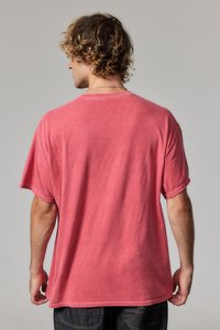 Camiseta de manga corta y cuello redondo en color coral desvanecido. Fabricada con una tela suave, tiene un ajuste holgado y detalles de costura visibles.